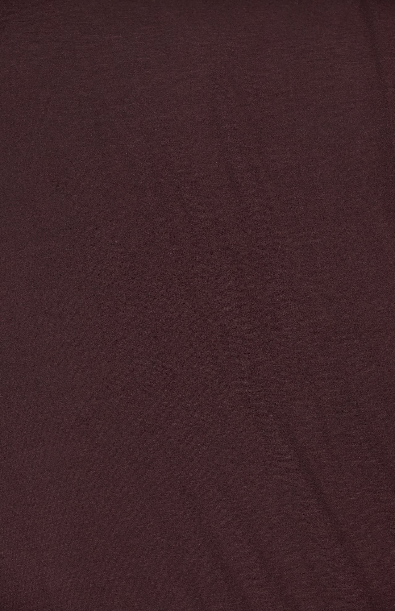 A close-up view of the ETERNE Long Sleeve Turtleneck Maxi Dress shows its plain dark maroon jersey modal blend fabric, highlighting subtle creases and texture.
