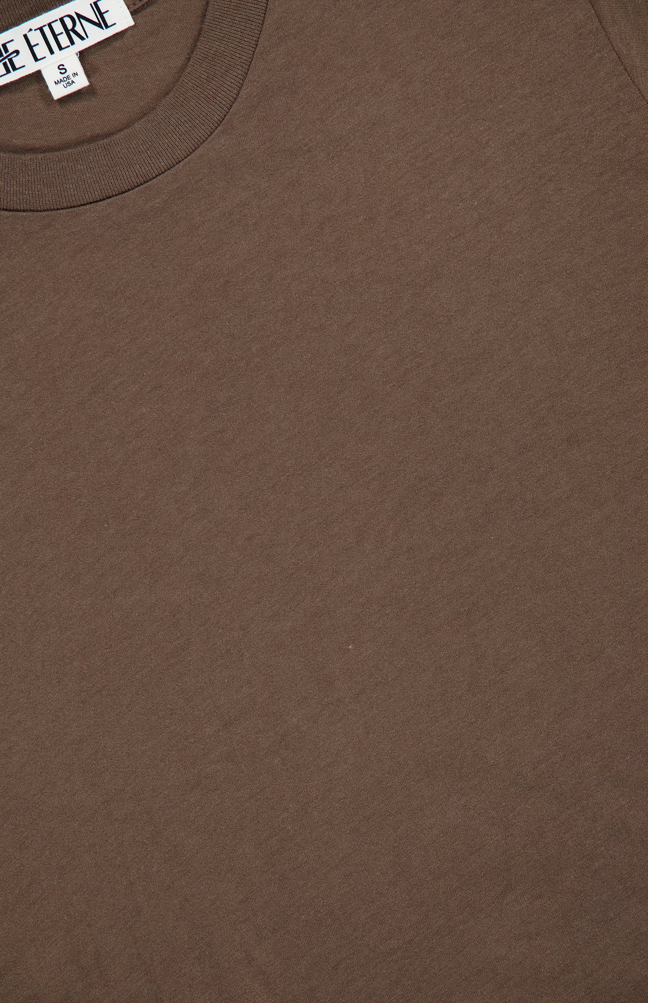 Close-up of the ETERNE Short Sleeve Boxy T-shirt, featuring the neckline and a partial view of a white clothing label with black text. The smooth and soft cotton-blend fabric makes this tee perfect for everyday wear.