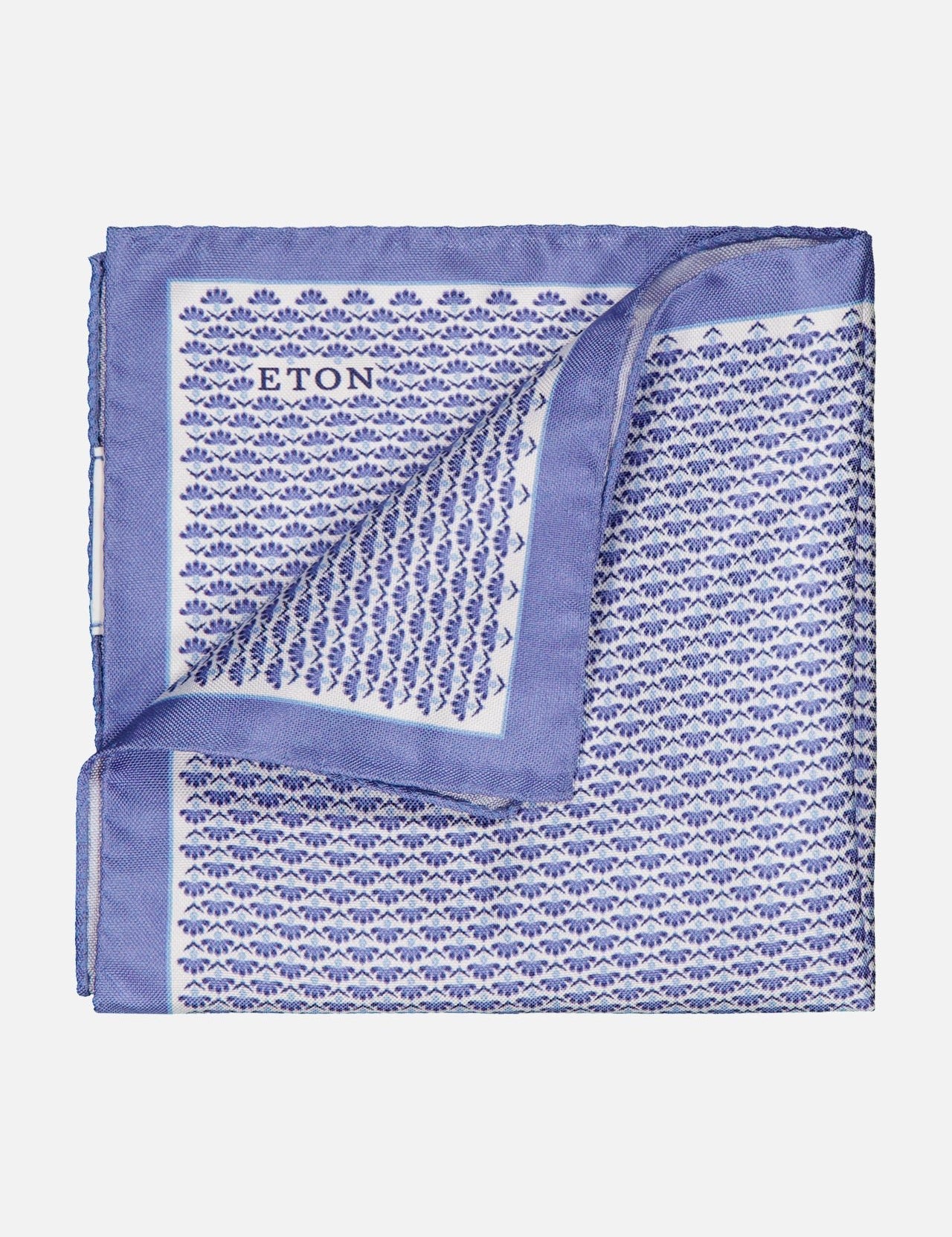 A luxury accessory, the ETON Floral Oxford Silk Pocket Square showcases a blue and white floral pattern, folded corner, subtle geometric design, solid blue border, and discreet ETON branding near the top edge.