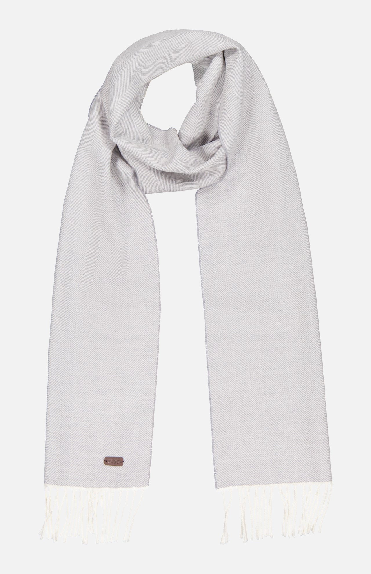 The ETON Herringbone Merino Wool Scarf is light gray with a subtle herringbone pattern, white fringe on both ends, and a small rectangular tag near one edge. Neatly folded, it’s set against a plain white background.