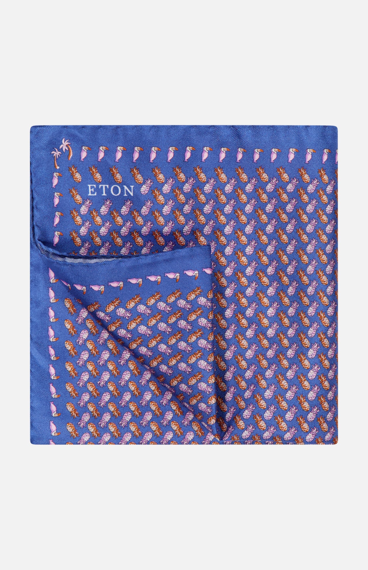 The ETON Ananas Silk Twill Pocket Square is blue with a repeating orange and pink pineapple pattern; one corner is folded to display the reverse side.