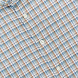 Close-up of the ETON Check Twill Contemporary Dress Shirt in light blue, featuring a subtle orange and white plaid pattern. The collar displays an ETON fabric label. Made from organic cotton, this dress shirt combines style and sustainability with four visible white buttons on the front.