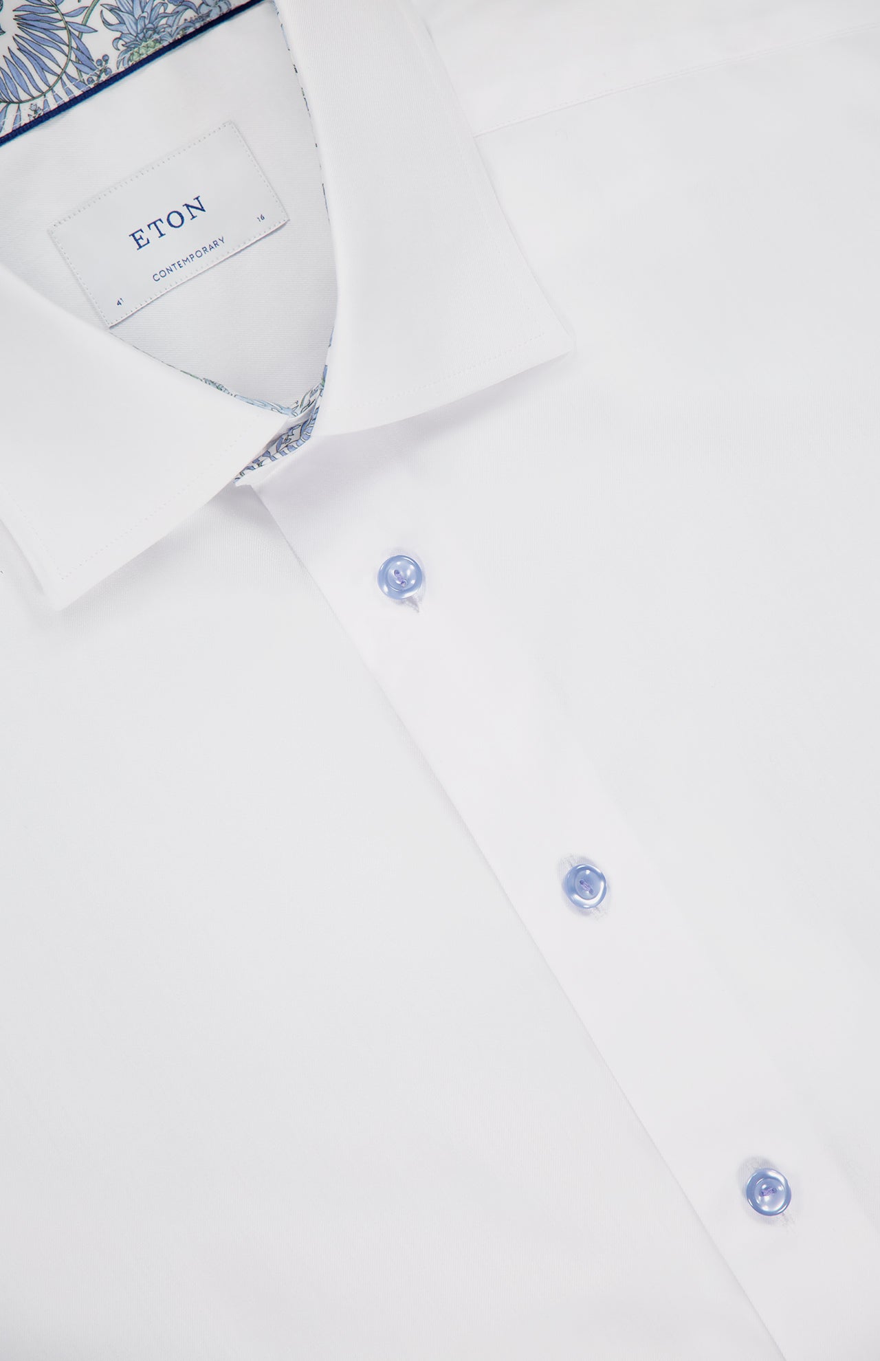 Close-up of the ETON Floral Effect Signature Twill Dress Shirt, featuring light blue buttons and patterned fabric inside the collar—a wrinkle-resistant, refined option for formal occasions.