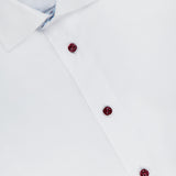 A close-up of ETON’s Geometric Effect Signature Twill Slim Dress Shirt in white, showcasing three maroon buttons, a classic collar, and the partially visible wrinkle-resistant label inside.