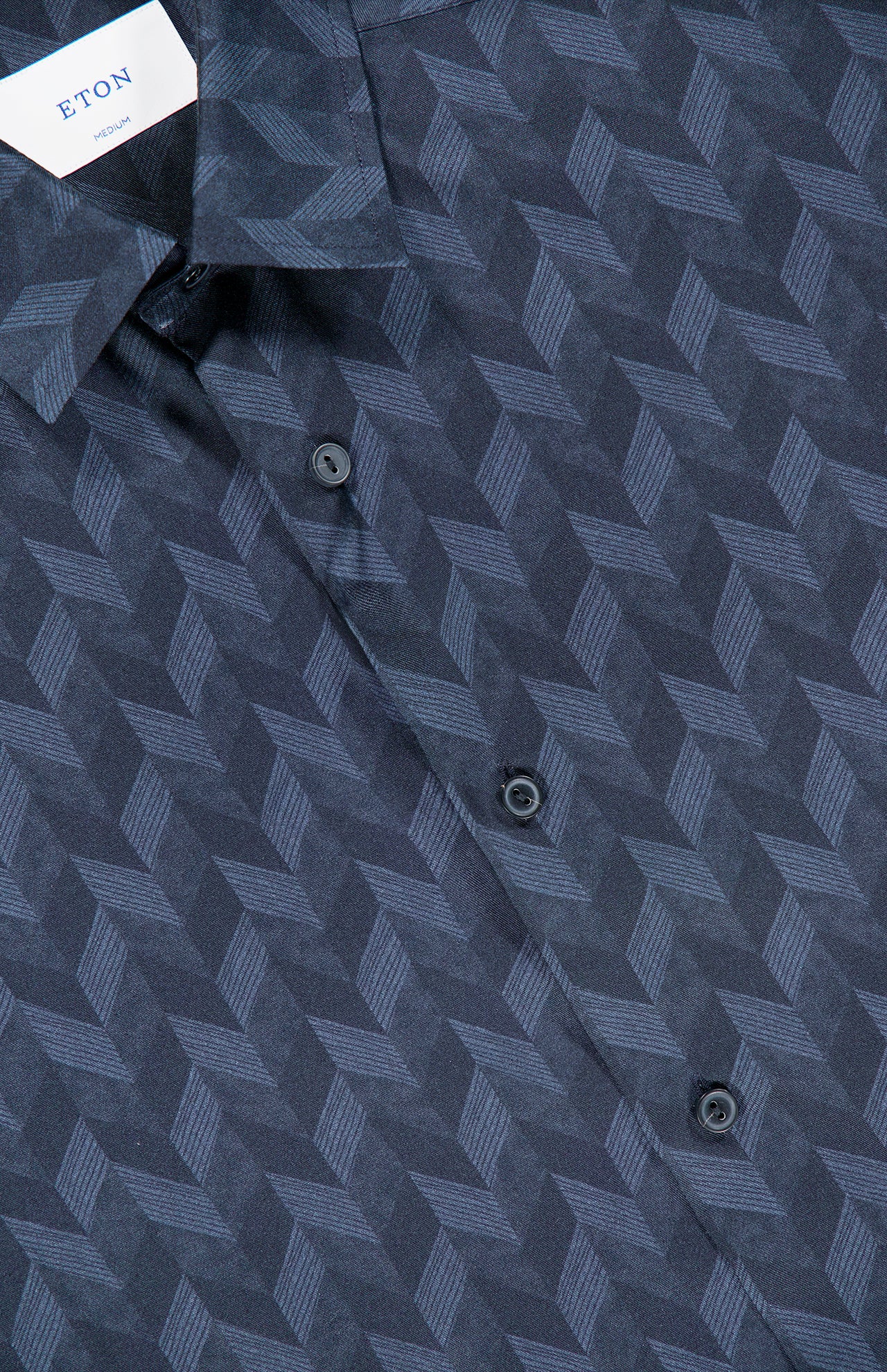 Close-up of a dark blue ETON Geometric Lyocell Dress Shirt featuring a diagonal chevron print and black buttons. The ETON brand label is partially visible inside the collar.