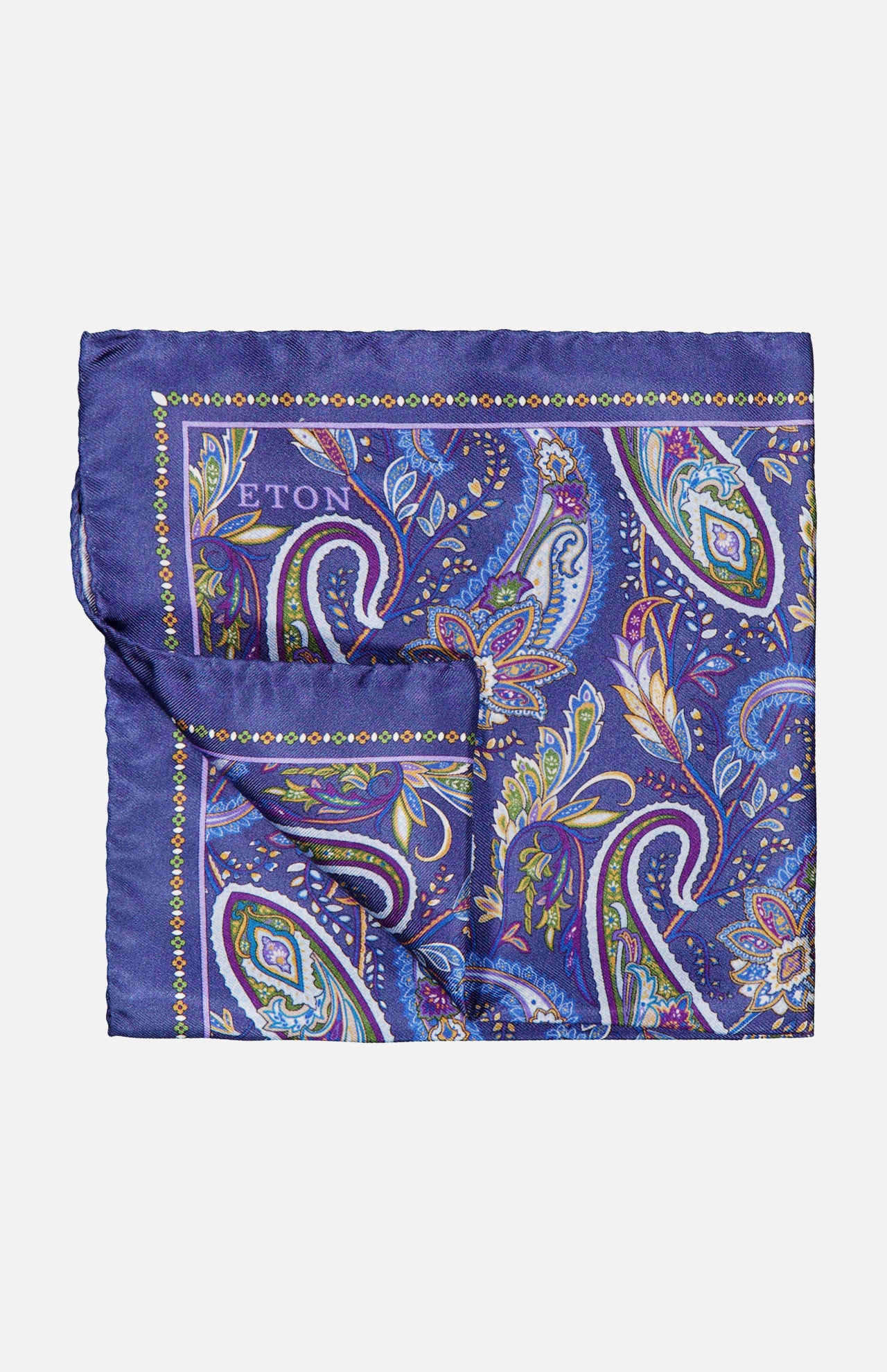 The ETON Paisley Silk Twill Pocket Square is a luxurious accessory crafted from fine silk, showcasing a vibrant blue background decorated with intricate paisley patterns in green, purple, yellow, and white. The brand name "ETON" is elegantly displayed in one corner of this distinguished blue silk pocket square.