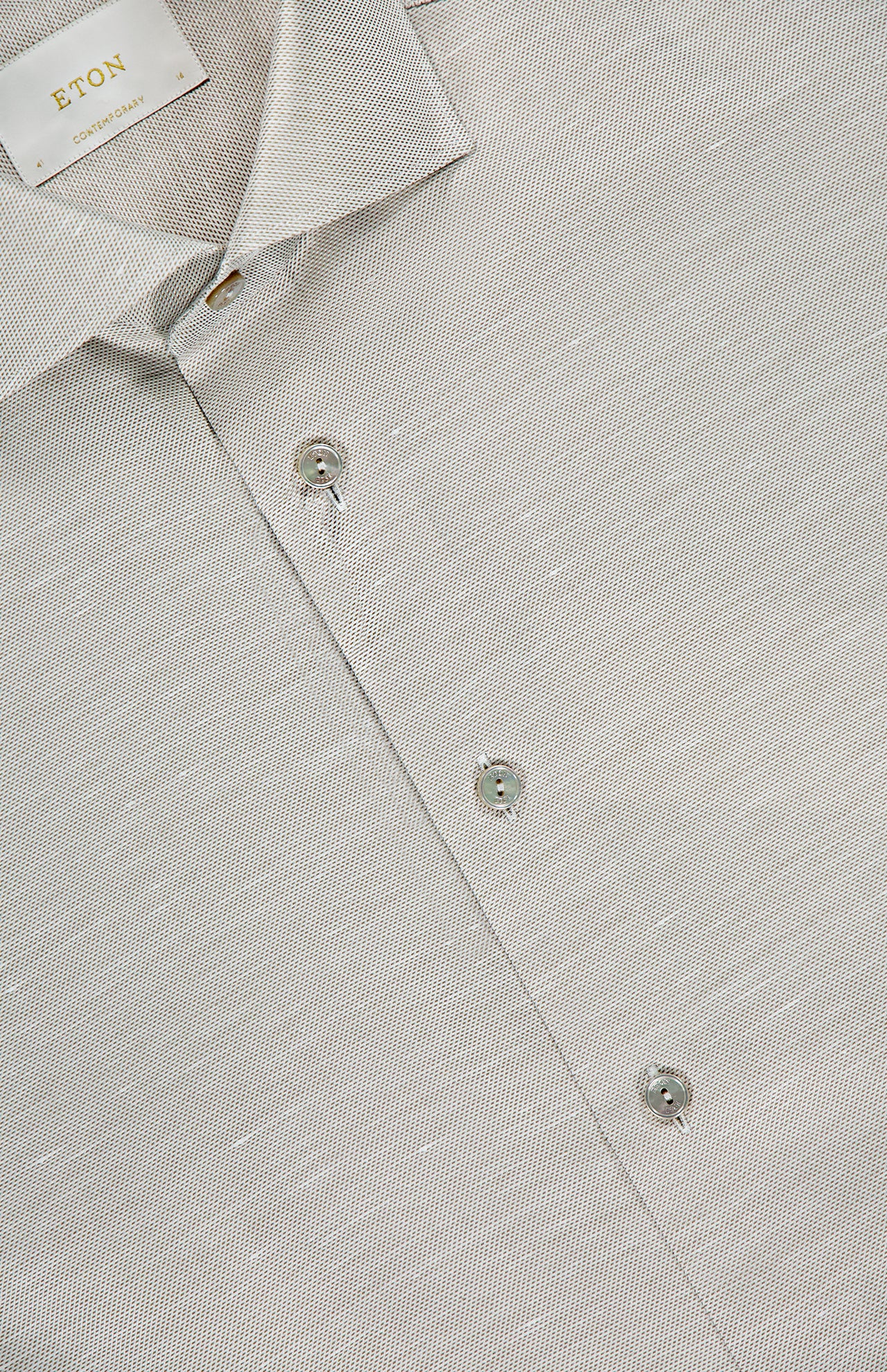 Close-up of ETON's Semi Solid Cotton Linen Dress Shirt in light gray. Features a textured slim-fit design, spread collar, and three visible buttons. The shirt label is in the top left—ideal for formal occasions.