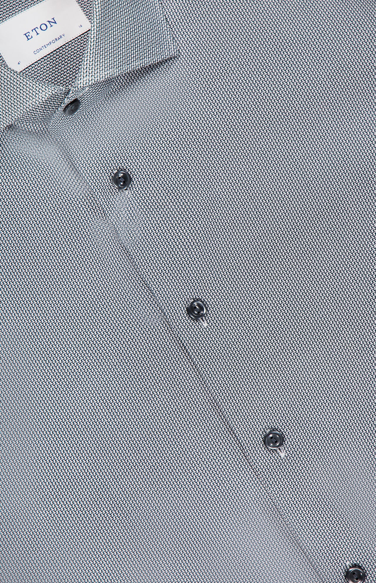 Close-up of the ETON Semi Solid Dobby Slim Dress Shirt in gray with a subtle geometric pattern, dark buttons, and a visible ETON CONTEMPORARY label inside the collar.