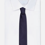 A neatly folded white dress shirt with a classic collar is paired with the ETON Semi Solid Woven Silk Tie in dark navy, displayed against a plain white background.