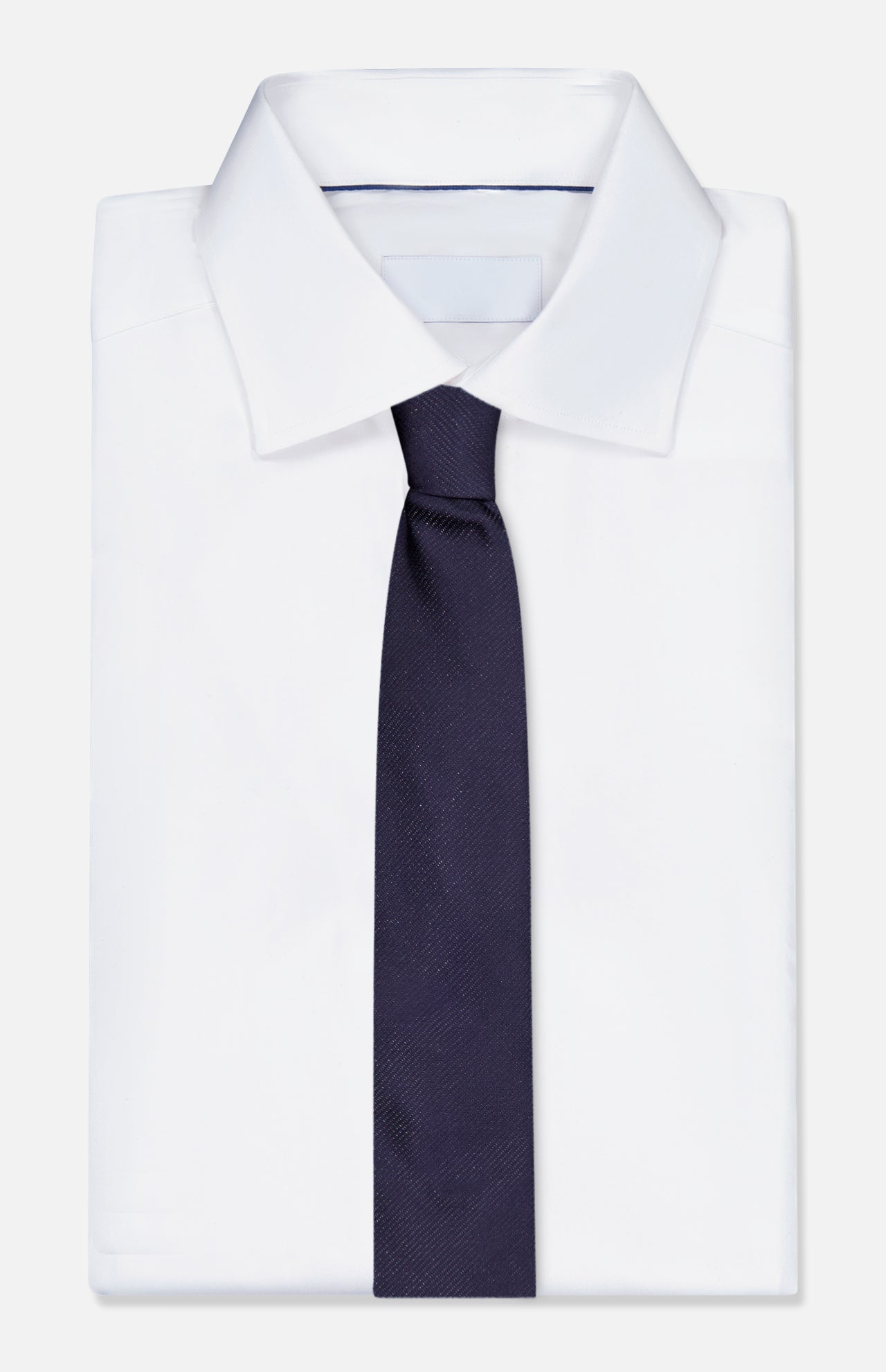 A neatly folded white dress shirt with a classic collar is paired with the ETON Semi Solid Woven Silk Tie in dark navy, displayed against a plain white background.