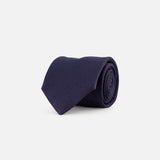The ETON Semi Solid Woven Silk Tie, crafted in Italy in a dark navy blue textured finish, is displayed neatly rolled on a plain white background.