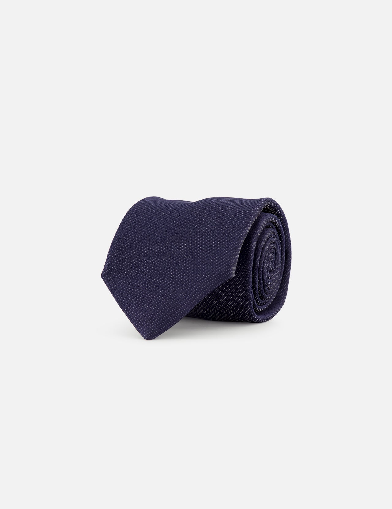 The ETON Semi Solid Woven Silk Tie, crafted in Italy in a dark navy blue textured finish, is displayed neatly rolled on a plain white background.