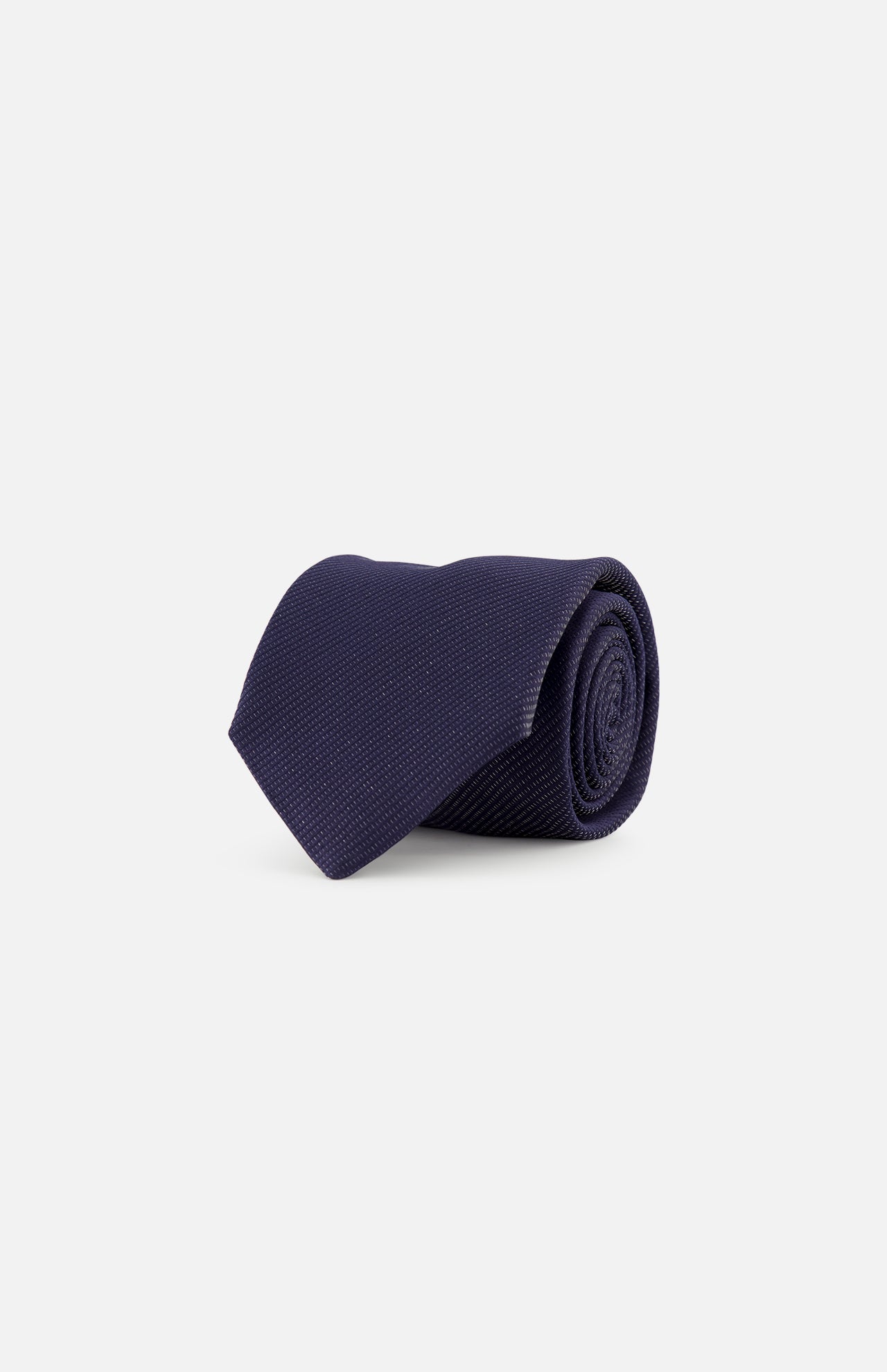The ETON Semi Solid Woven Silk Tie, crafted in Italy in a dark navy blue textured finish, is displayed neatly rolled on a plain white background.