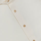 An off-white Solid Flannel Shirt by ETON, featuring beige buttons and a collar tag that displays “ETON” and “MEDIUM,” is shown neatly folded on a flat surface. Designed for casual comfort, this cotton shirt exudes effortless style.