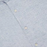 Close-up of ETON's Solid Linen Dress Shirt in pale blue, with white buttons and a subtly textured fabric. The image highlights the collar and upper chest, emphasizing the classic linen weave and refined style.