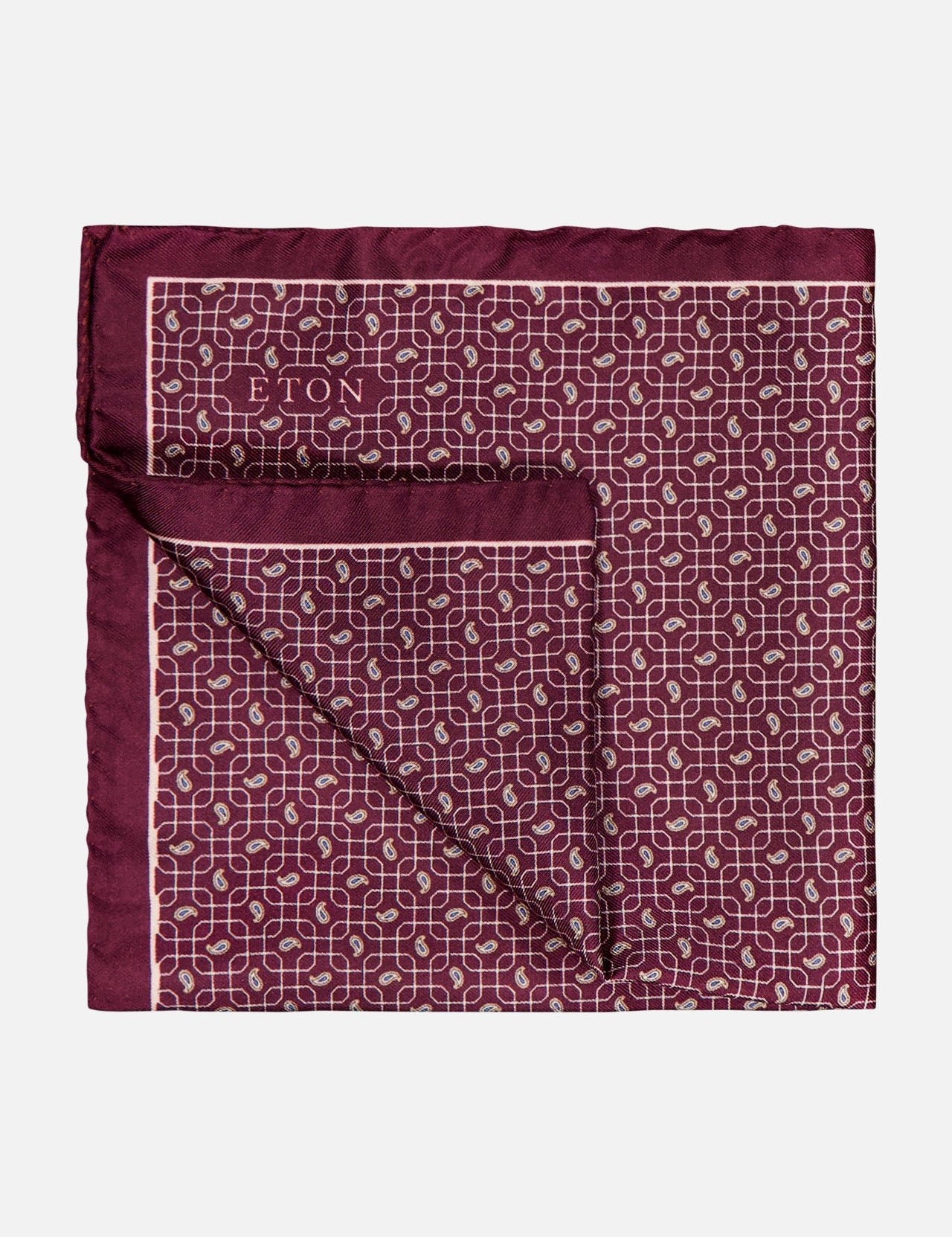 The ETON Motif Silk Paisley Pocket Square features a dark red paisley pattern with white geometric accents and a thin light pink border, partially folded to show both sides. The ETON logo appears in one corner.