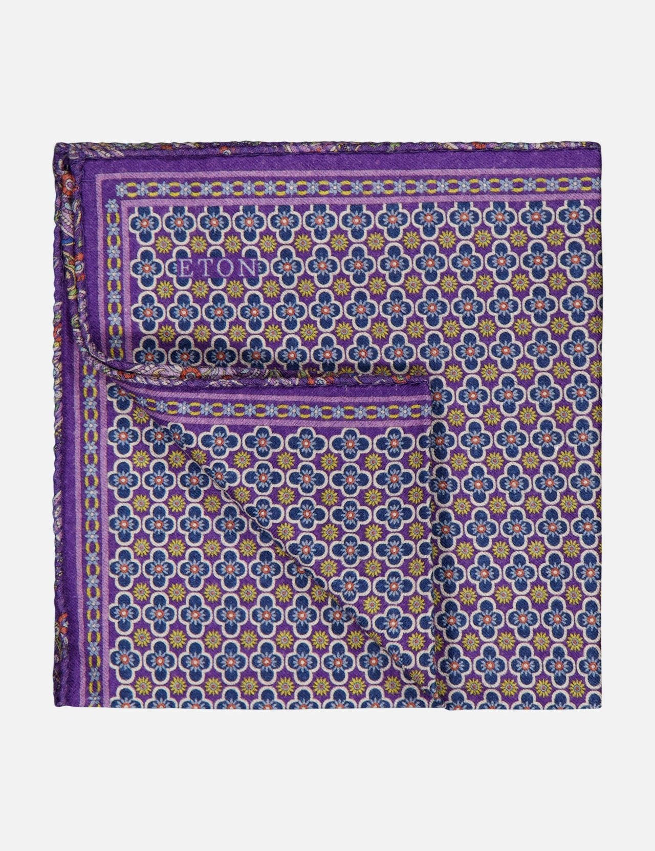 The ETON Two-Face Wool Pocket Square features a geometric floral pattern in purple, blue, and gold tones, is made in Italy, and includes a small ETON logo in the corner.