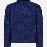 The ETRO Knitted Pattern Jacket, crafted in Italy, showcases a textured blue geometric design. This navy jacket features long sleeves, a collar, and snap button cuffs, and is displayed from the back against a plain background.