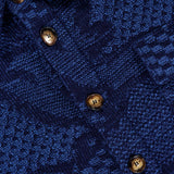 Close-up of the ETRO Knitted Pattern Jacket, showcasing a blue textured fabric with a geometric pattern and four brown buttons on the front placket, reflecting refined Italian craftsmanship.