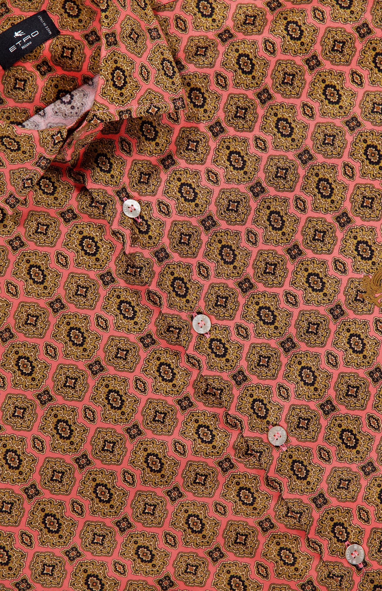 Close-up of the ETRO Roma Cotton Logo Shirt for men, featuring intricate pink, yellow, and black geometric medallion motifs in a repeating pattern. The shirt displays white buttons, a visible collar and label, evoking the stylish signature aesthetic of ETRO.