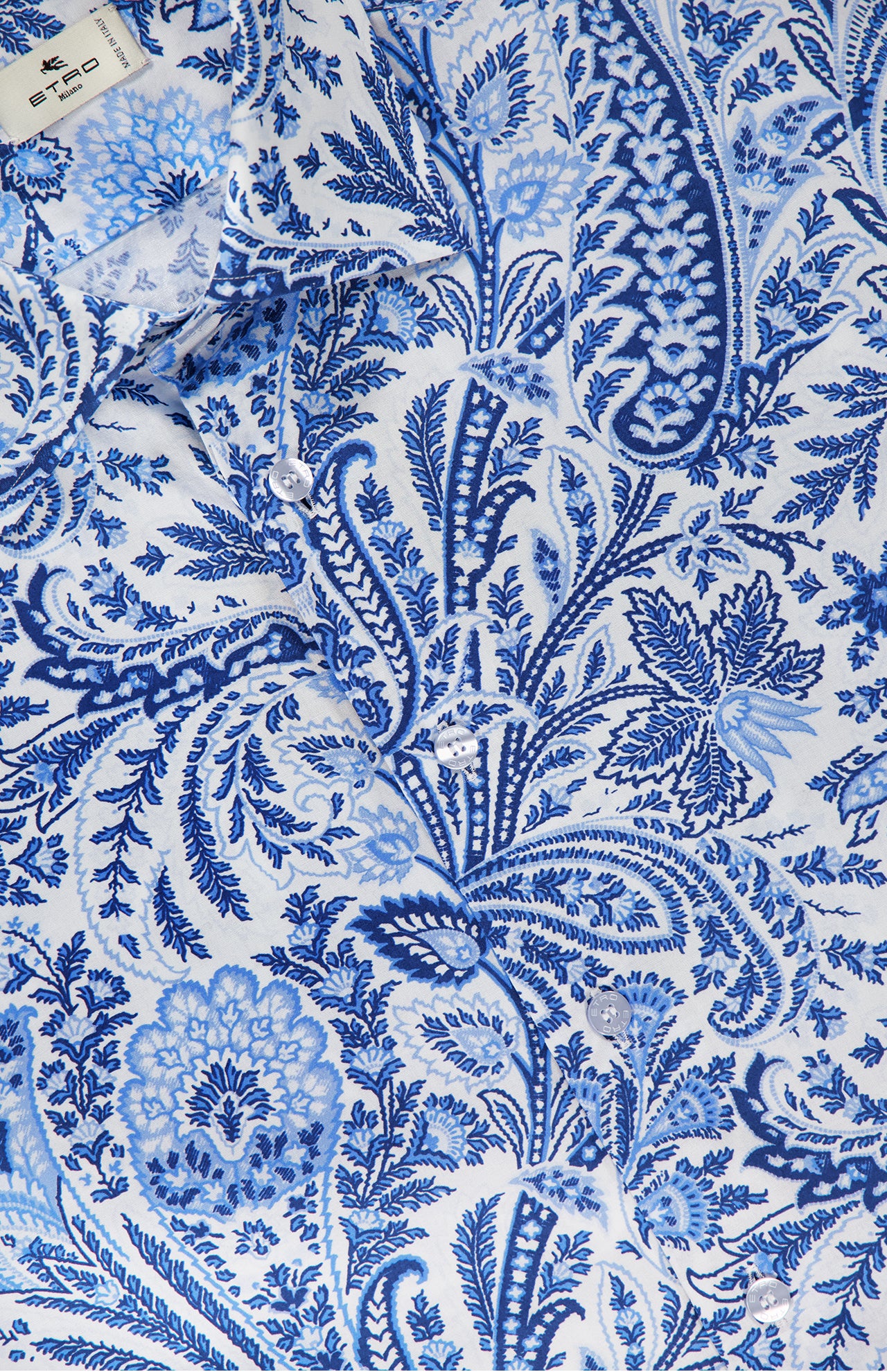 A detailed view of the ETRO Paisley Long Sleeve Shirt in stretch cotton, showcasing a blue floral and botanical pattern, white buttons, and part of the label at the top left.