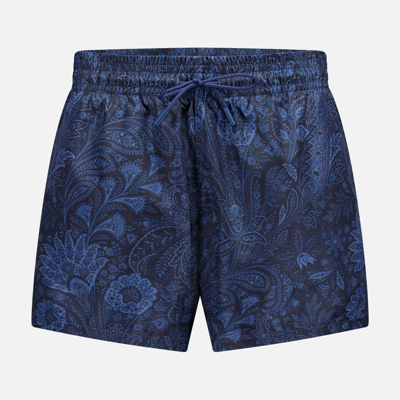 The ETRO Paisley Print Swim Trunk features a navy design with a drawstring waist and a subtle light blue paisley pattern. This stylish men's swimwear is shown on a plain light gray background.
