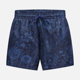 The ETRO Paisley Print Swim Trunk features a navy design with a drawstring waist and a subtle light blue paisley pattern. This stylish men's swimwear is shown on a plain light gray background.