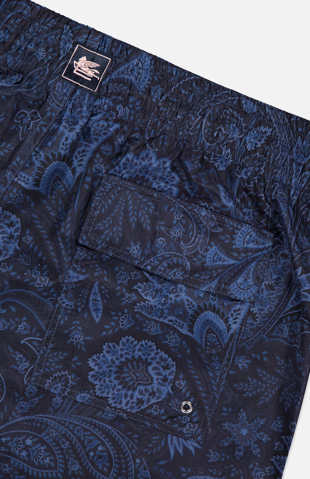 ETRO’s Paisley Print Swim Trunk features a navy paisley pattern, elastic waistband, flap back pocket with metal eyelet, and an embroidered logo patch—an essential for stylish men's swimwear.