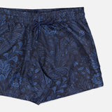 The ETRO Paisley Print Swim Trunk features a subtle paisley design, dark blue color, elastic waistband with drawstring, relaxed fit, and is shown on a plain white background.