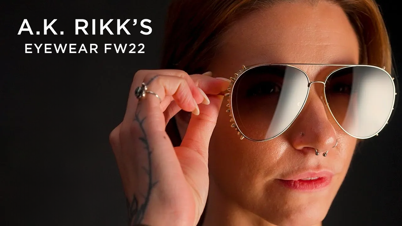 image with text "A.K. Rikk's eyewear FW22" image is a close up of a model wearing a pair of aviator style sunglasses" 