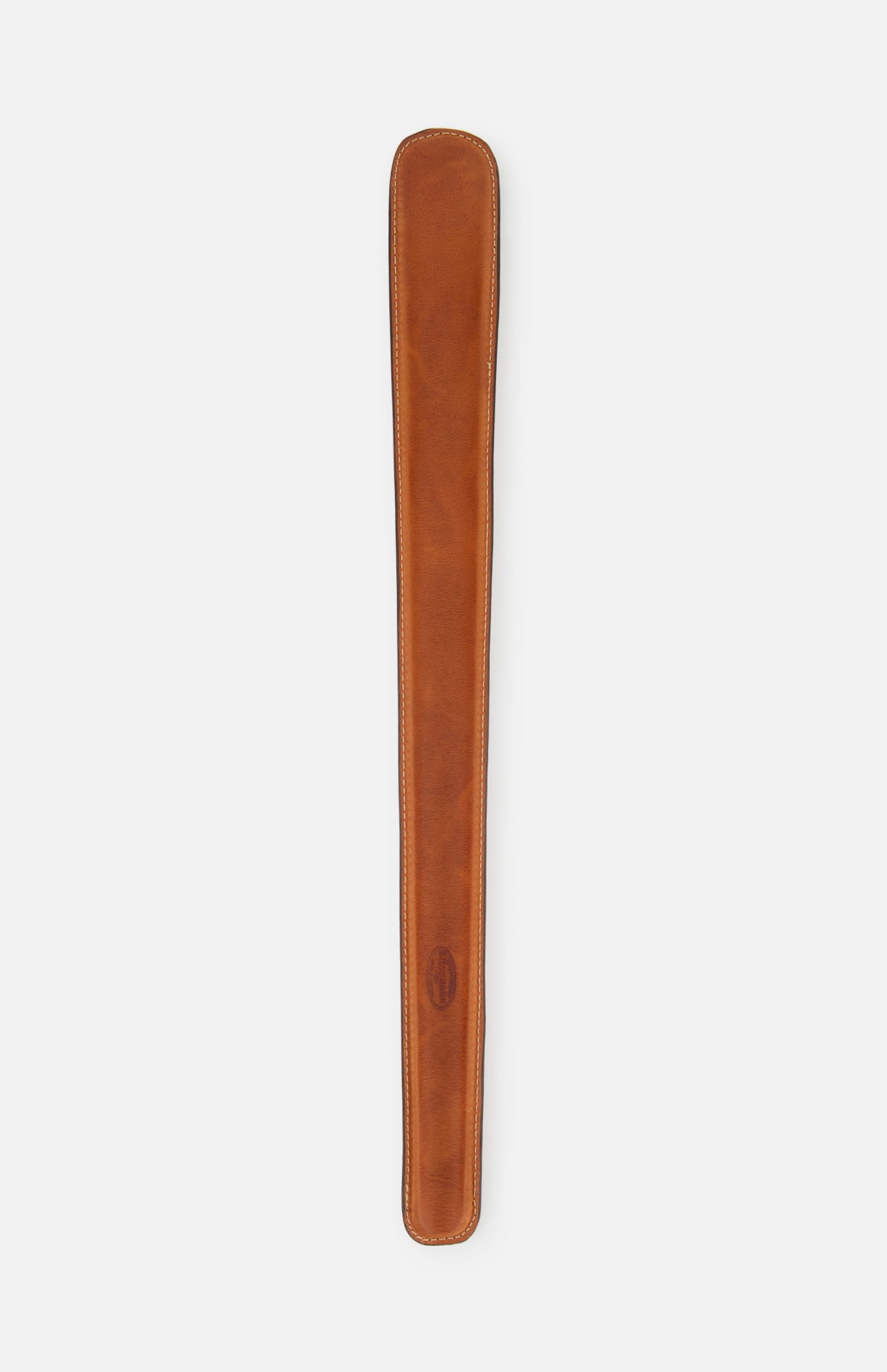 The F. HAMMANN Cowhide Shoehorn is a long, narrow brown leather case with rounded ends and visible stitching, crafted in Germany and shown against a plain white background.