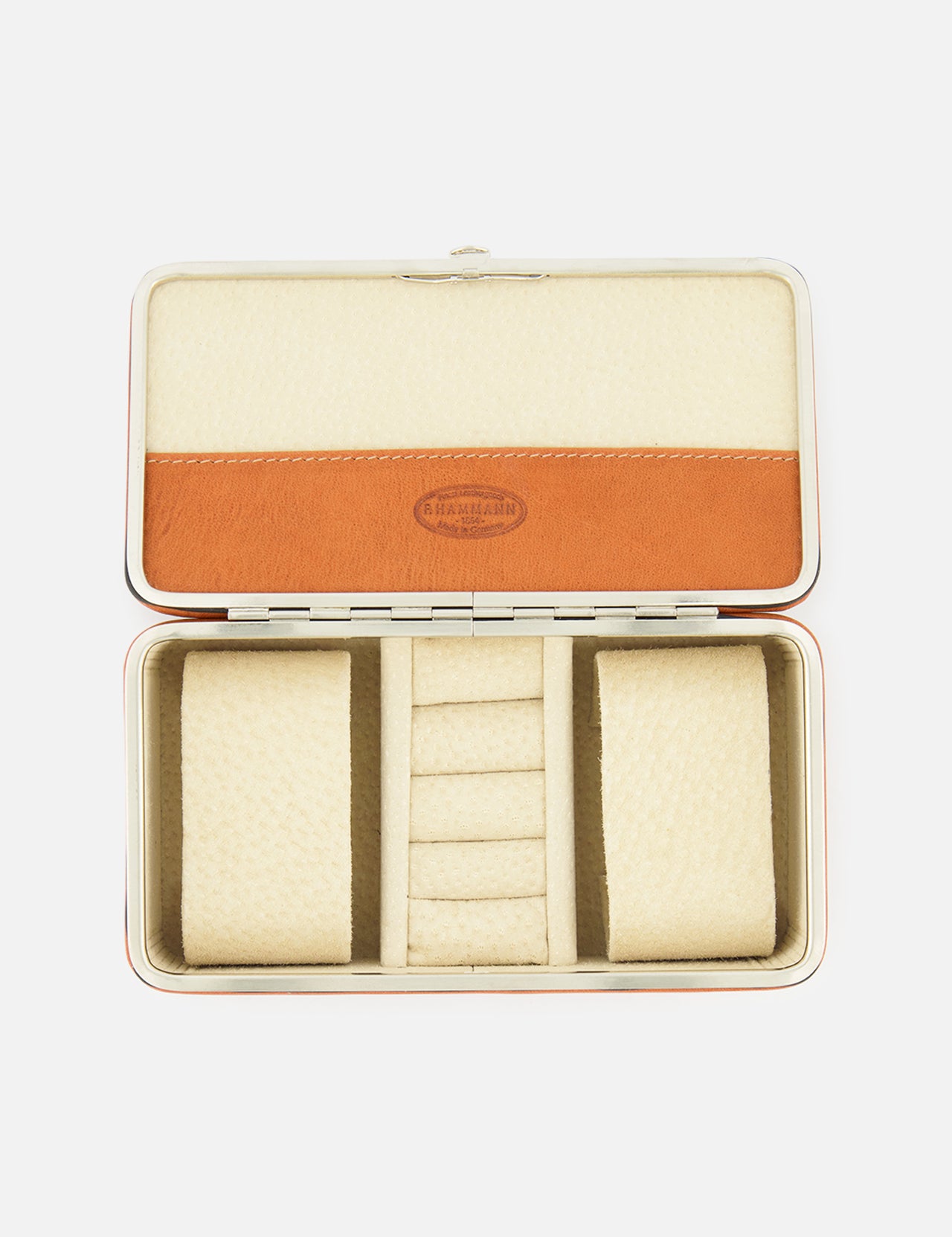 The F. HAMMANN Cowhide Jewelry Box is a rectangular, open leather case with a beige and tan interior, two cushioned side compartments, and a center section with four ring slots—an elegant travel jewelry organizer.