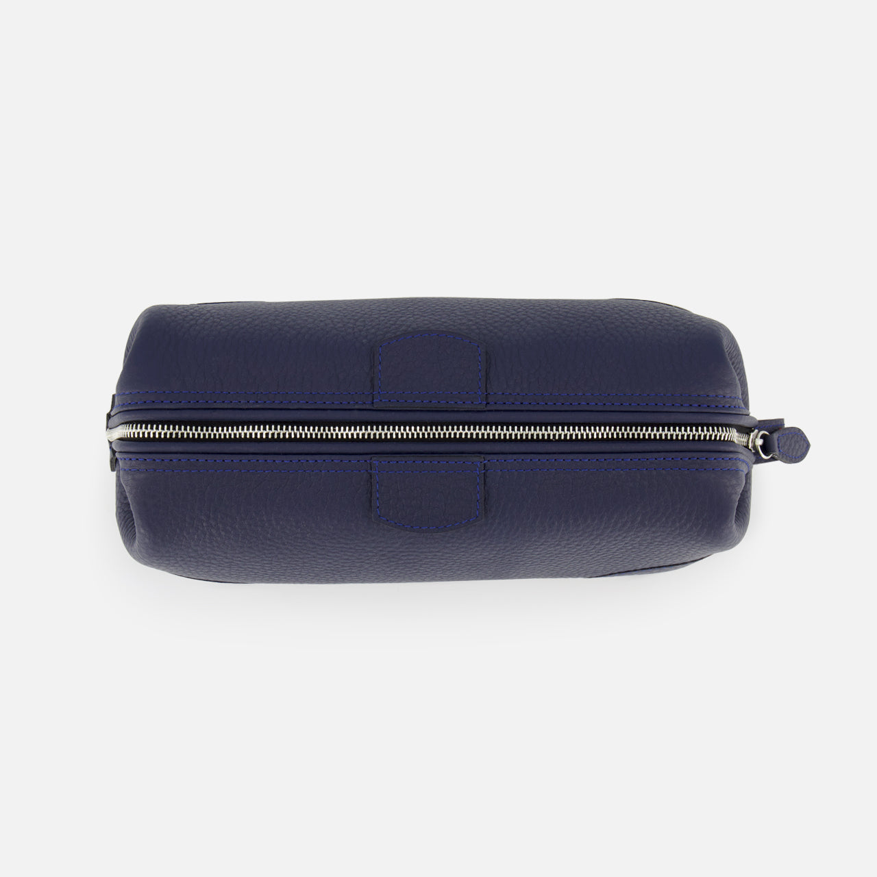 The Mousetrap Flat Toiletry Bag by F. HAMMANN is shown from above in navy blue leather, featuring a silver zipper along the top with a small pull tab—an elegant travel accessory.