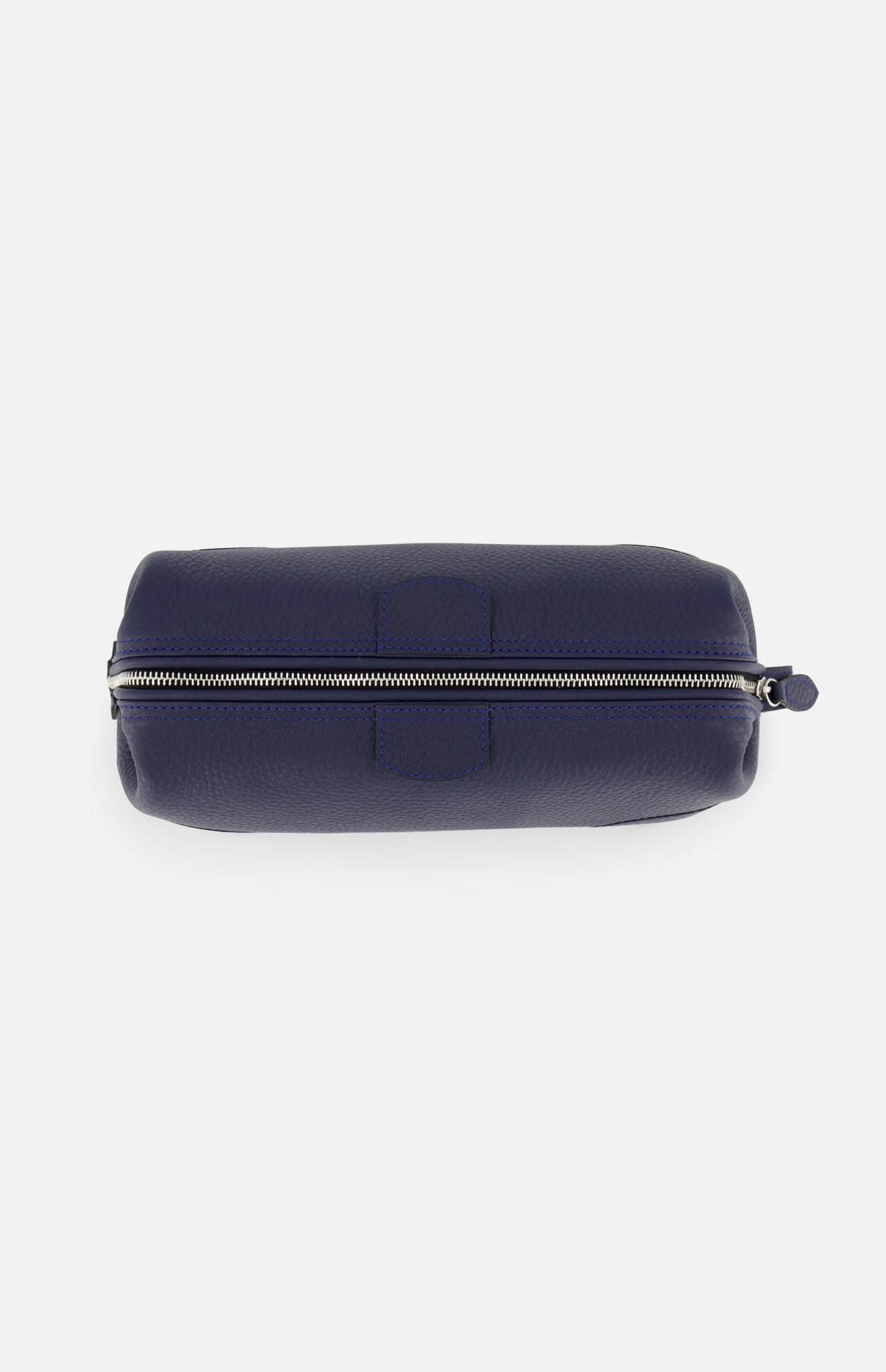 The Mousetrap Flat Toiletry Bag by F. HAMMANN is shown from above in navy blue leather, featuring a silver zipper along the top with a small pull tab—an elegant travel accessory.