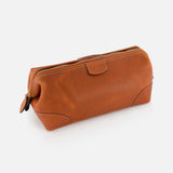 The Mousetrap Flat Toiletry Bag by F. HAMMANN is a brown leather, rectangular travel accessory with rounded corners and visible stitching, shown against a white background.