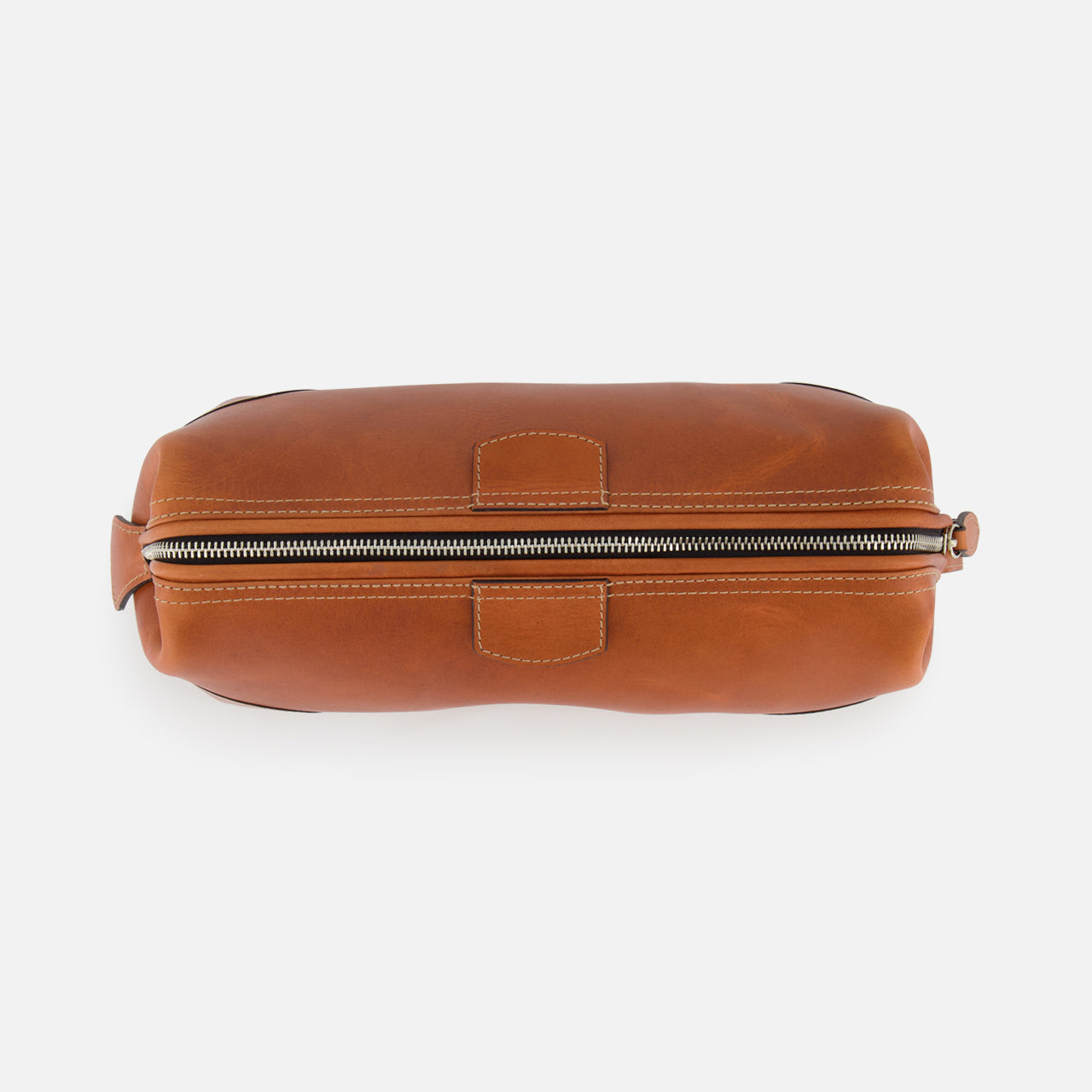 A top-down view of The Mousetrap Flat Toiletry Bag by F. HAMMANN, featuring brown leather, visible stitching, and a zippered closure on a white background—a stylish and durable travel accessory.