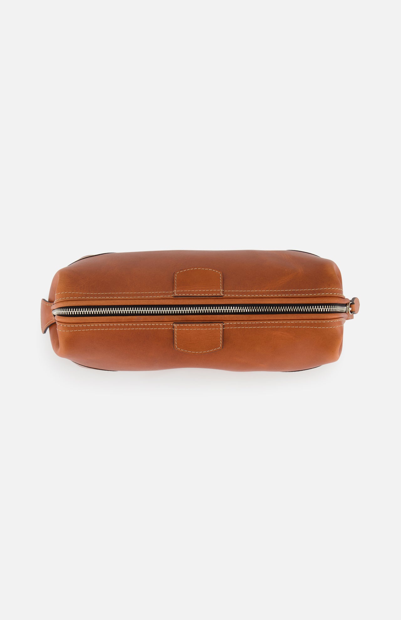 A top-down view of The Mousetrap Flat Toiletry Bag by F. HAMMANN, featuring brown leather, visible stitching, and a zippered closure on a white background—a stylish and durable travel accessory.