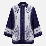 The Coast Scarf Wide Sleeve Shirt by FARM RIO is a long-sleeve, button-up with a white base, detailed purple floral and fruit embroidery, and bold purple sleeves—perfect for making a statement on vacation.