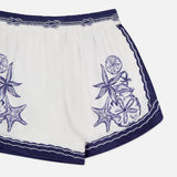 The Coast Scarf Shorts by FARM RIO showcase a dark blue waistband and hem, with embroidered sea star and sand dollar accents. The image highlights the upper half on a clean white background—ideal for coastal getaways.
