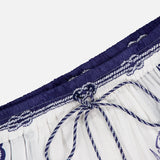 A close-up of Coast Scarf Shorts by FARM RIO, featuring blue floral patterns, a dark blue elastic waistband with a drawstring, and decorative stitching—ideal for a coastal vacation look.