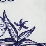 A close-up of the Coast Stars Linen Mini Dress by FARM RIO, featuring white linen embroidered with navy seashells, starfish, and scalloped wave patterns—ideal for a chic coastal party look.