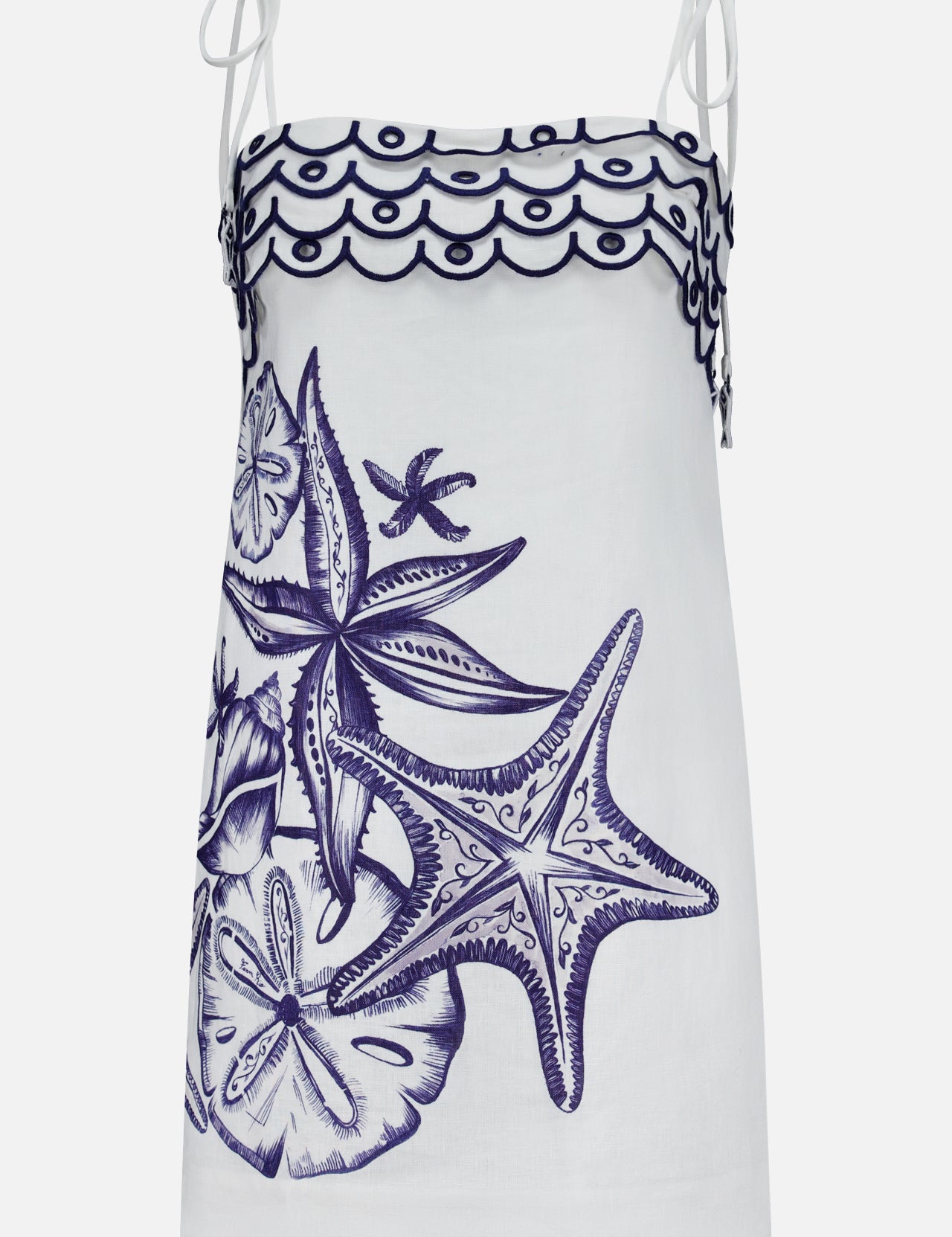 The Coast Stars Linen Mini Dress by FARM RIO is a white sleeveless mini dress with thin shoulder ties, navy embroidered starfish and seashells, plus a wavy hem—ideal as an embroidered summer dress.