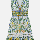 The Emily Floral Tapestry Mini Dress by FARM RIO is a sleeveless white mini dress with a V-neck, waist tie, green, blue, and yellow floral embroidery, ruffled hem, and intricate details for a breezy, playful style.
