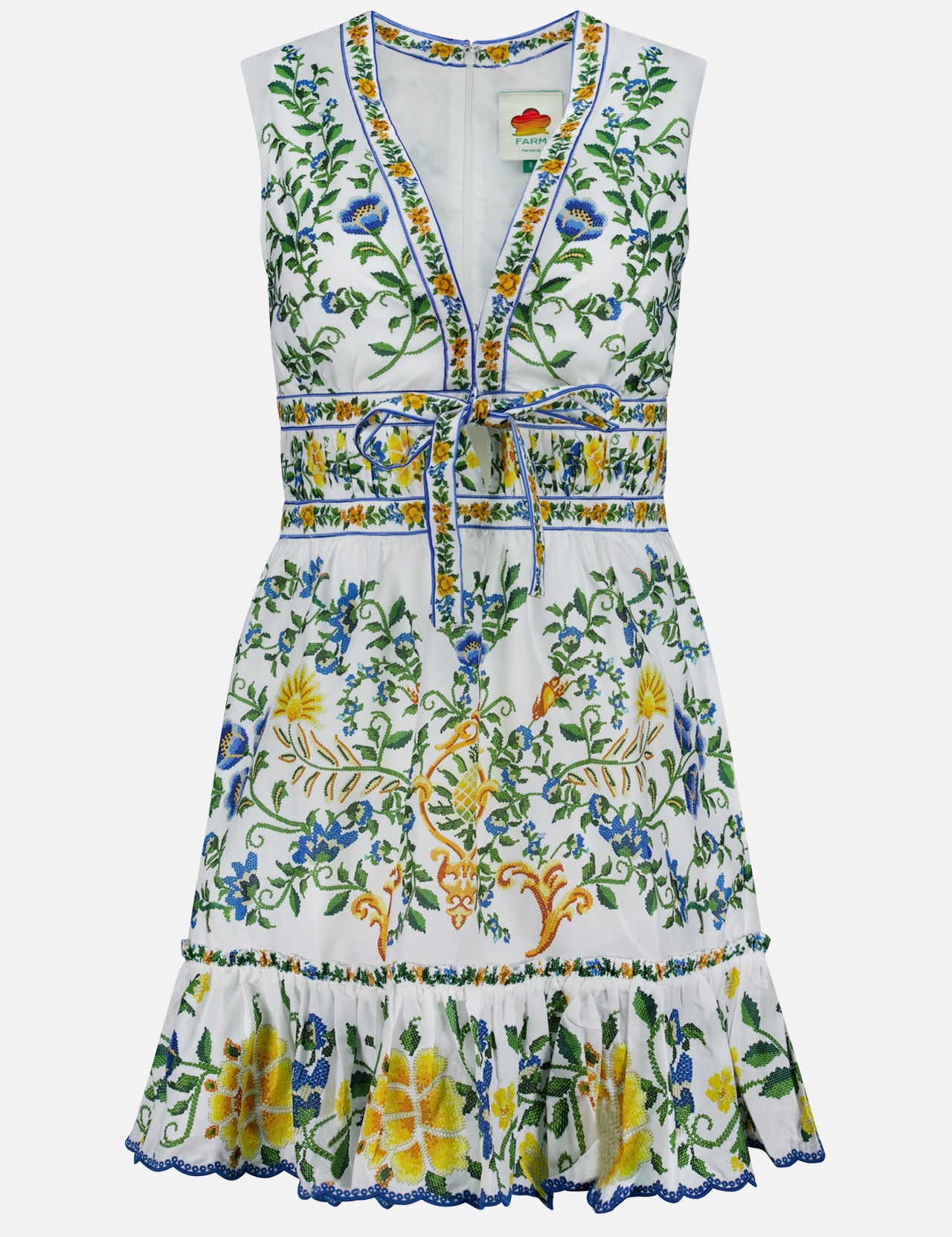 The Emily Floral Tapestry Mini Dress by FARM RIO is a sleeveless white mini dress with a V-neck, waist tie, green, blue, and yellow floral embroidery, ruffled hem, and intricate details for a breezy, playful style.