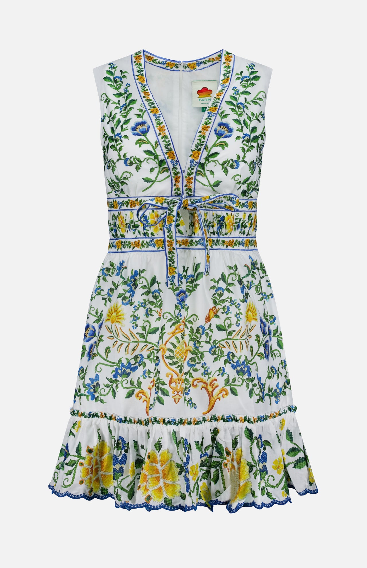 The Emily Floral Tapestry Mini Dress by FARM RIO is a sleeveless white mini dress with a V-neck, waist tie, green, blue, and yellow floral embroidery, ruffled hem, and intricate details for a breezy, playful style.