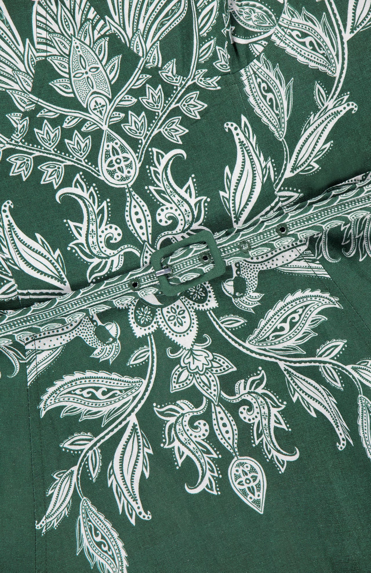 Close-up of the FARM RIO Miranda Belt Buckles Maxi Dress in dark green linen-blend, detailed with white floral and leaf prints. A coordinating belt with a square buckle defines the waist, creating an elegant resort-ready silhouette.
