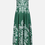 The FARM RIO Miranda Belt Buckles Maxi Dress is a sleeveless dark green maxi with white floral and leaf prints, decorative straps, a fitted bodice, flared skirt, and stylish belt buckles—ideal for resort wear.