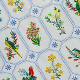 The FARM RIO Tropical Porcelain Maxi Dress features colorful parrots, yellow flowers, and green leaves in blue dotted hexagons on white cotton.
