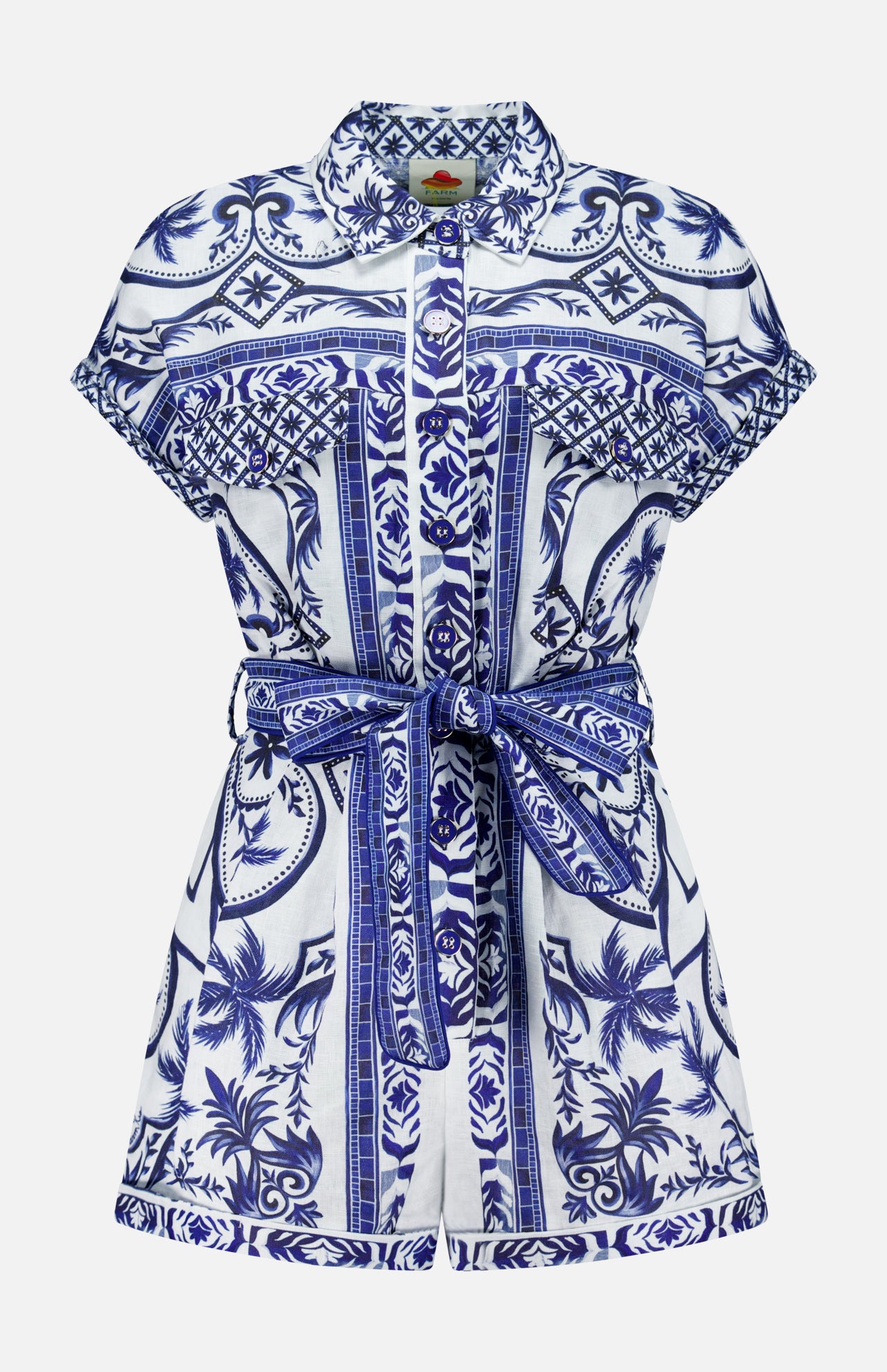The FARM RIO Wonderful City Linen Romper features short sleeves, a collared neckline, a blue and white nature-inspired floral and geometric print, a button-down front, and a matching fabric belt at the waist.