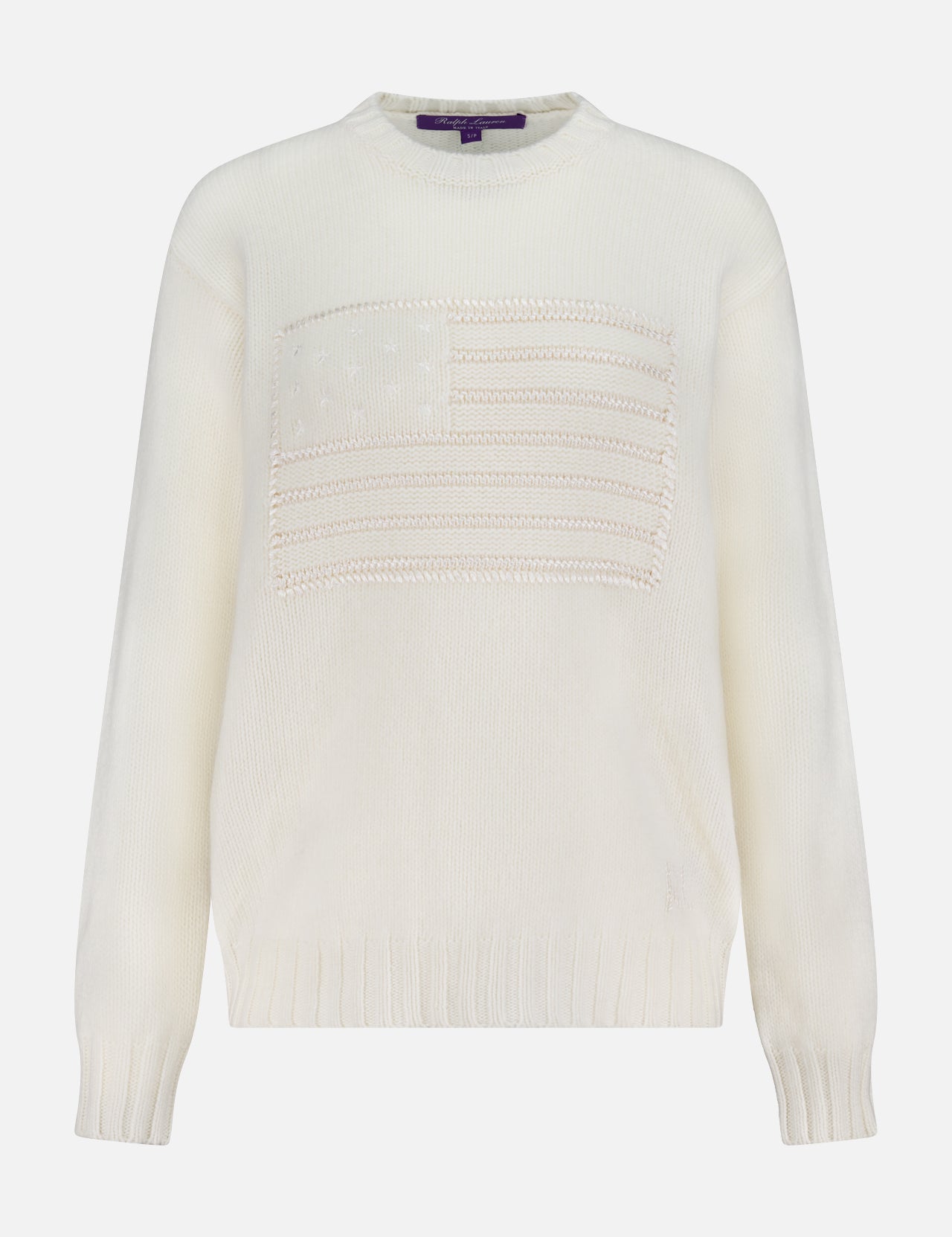 The Flag Sweater by RALPH LAUREN COLLECTION is a white cashmere crewneck featuring a textured American flag on the front, ribbed cuffs and hem, and varied knitting patterns inspired by the iconic Ralph Lauren design.